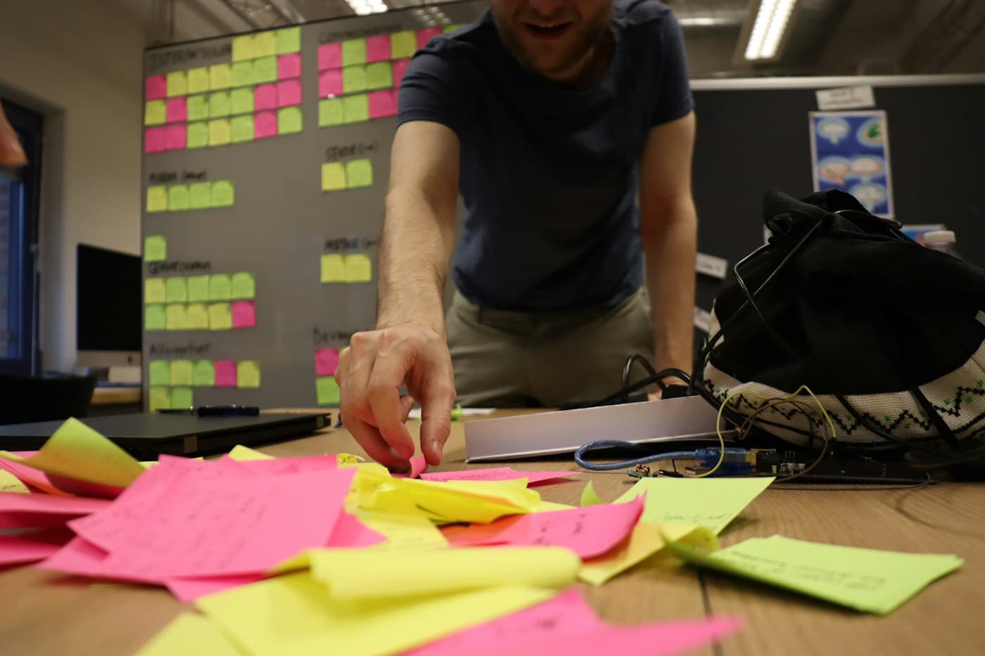 Foto: Pexels Een workshopdeelnemer sorteert gekleurde notities voor een planbord